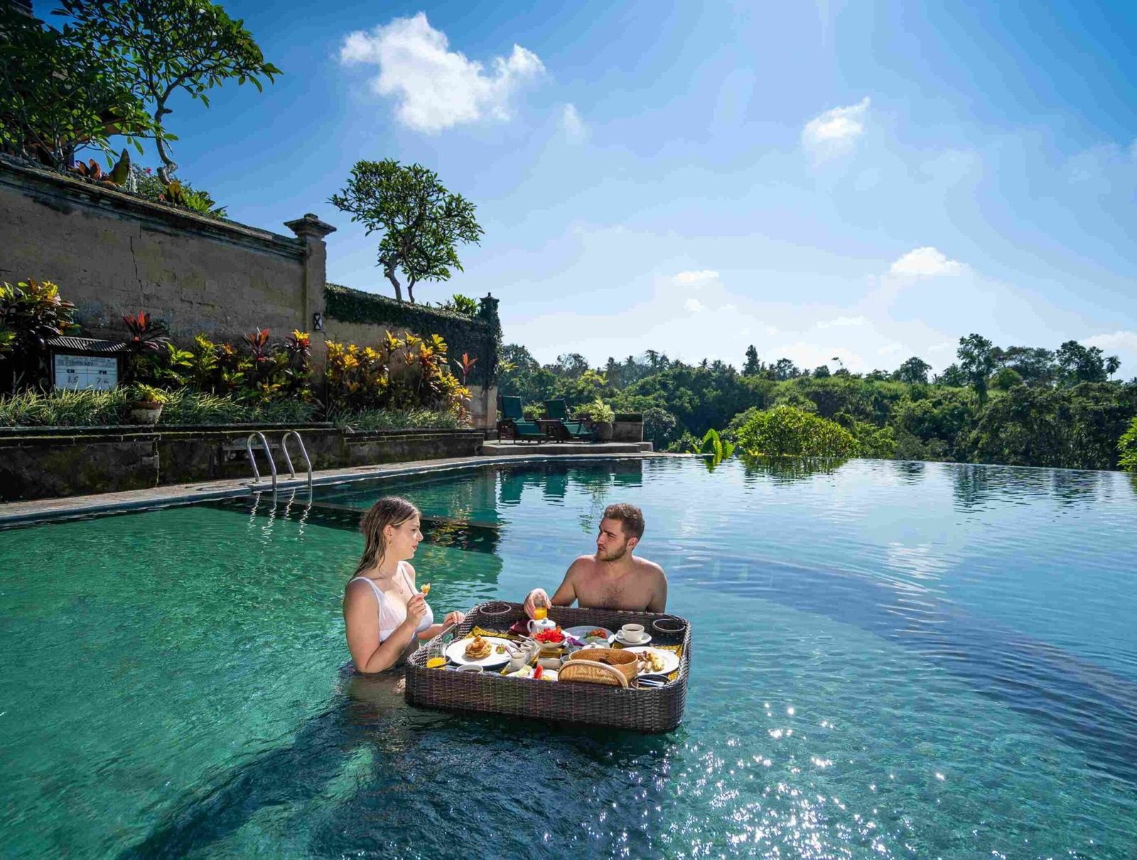 A couple sharing a floating breakfast in a jungle infinity pool in Bali
